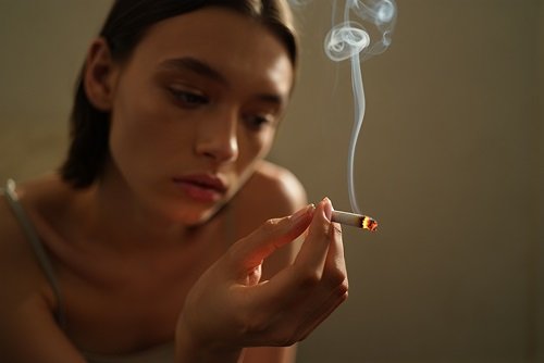 Девушка курит сигарету